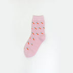 A single light pink crew sock with a repeating pattern of small orange carrots with green tops, displayed against a clean white background.