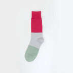 A single color-blocked sock with a bright pink ribbed cuff, a light gray midsection, and a sage green toe, shown against a plain white background.