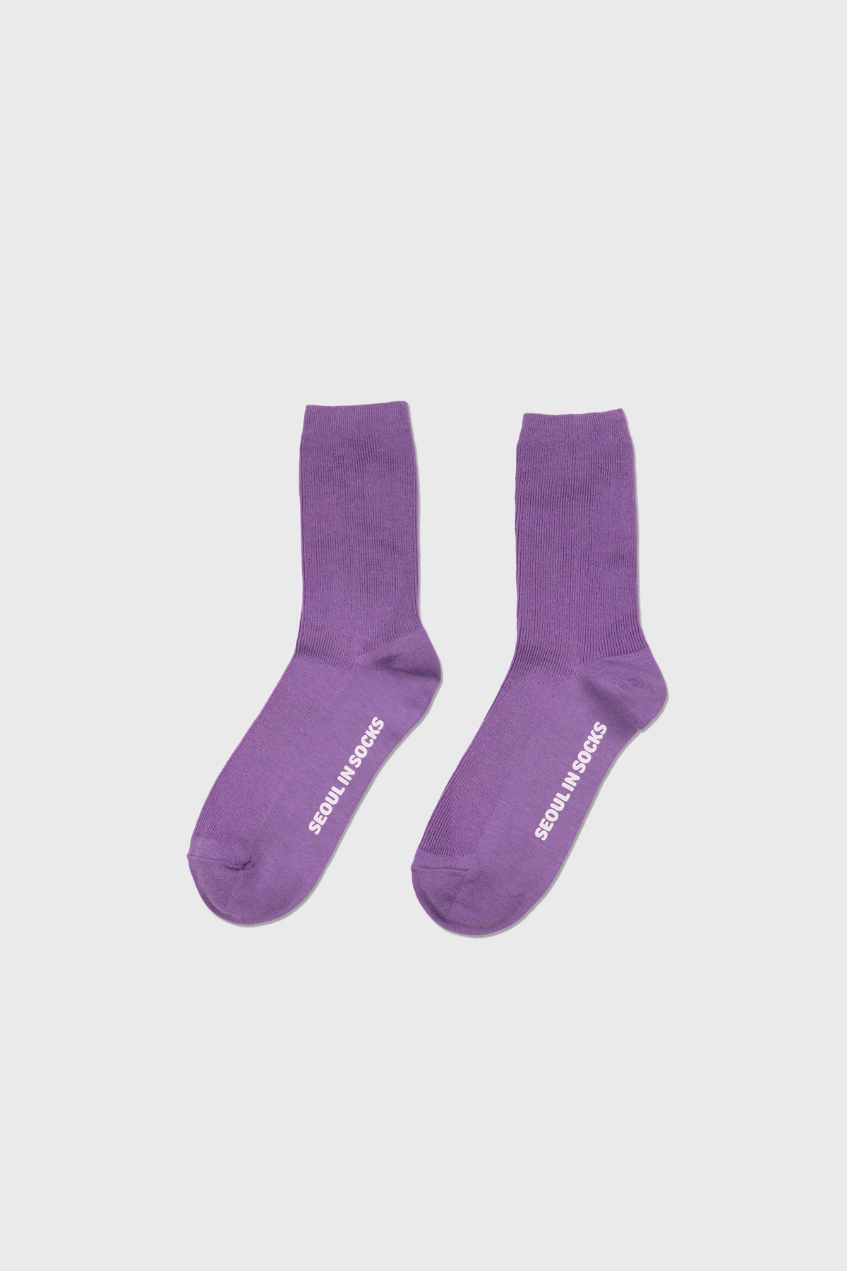 A pair of purple crew socks with white text reading 'SEMINAR SOCKS' printed on the soles, displayed against a light gray background.