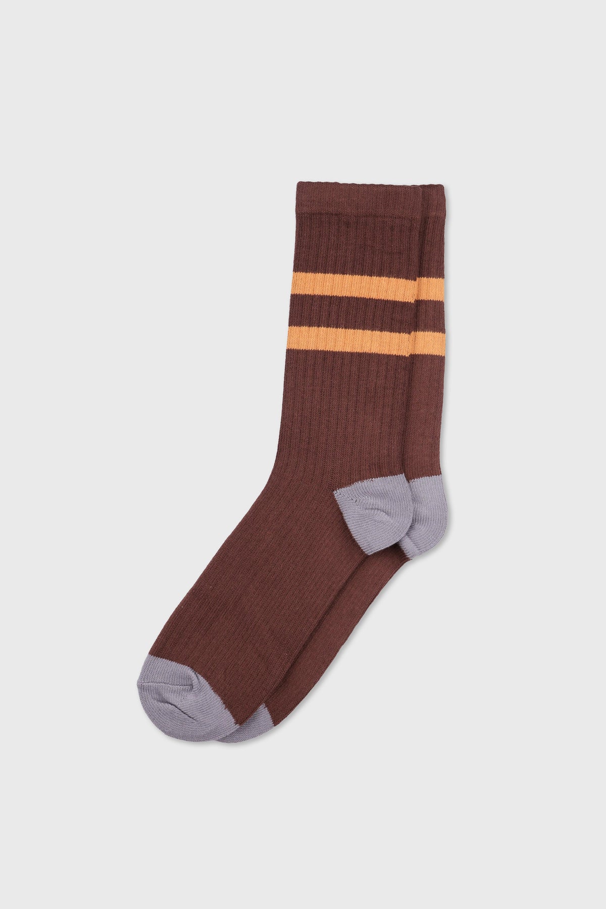 A pair of ribbed crew socks in dark brown with two horizontal orange stripes near the cuff and light gray heels and toes, shown on a light gray background.