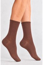A pair of medium brown crew socks worn on a person's feet, shown against a plain light gray studio background.
