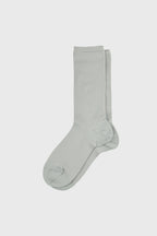 A pair of light sage green crew socks displayed flat against a solid light gray background.