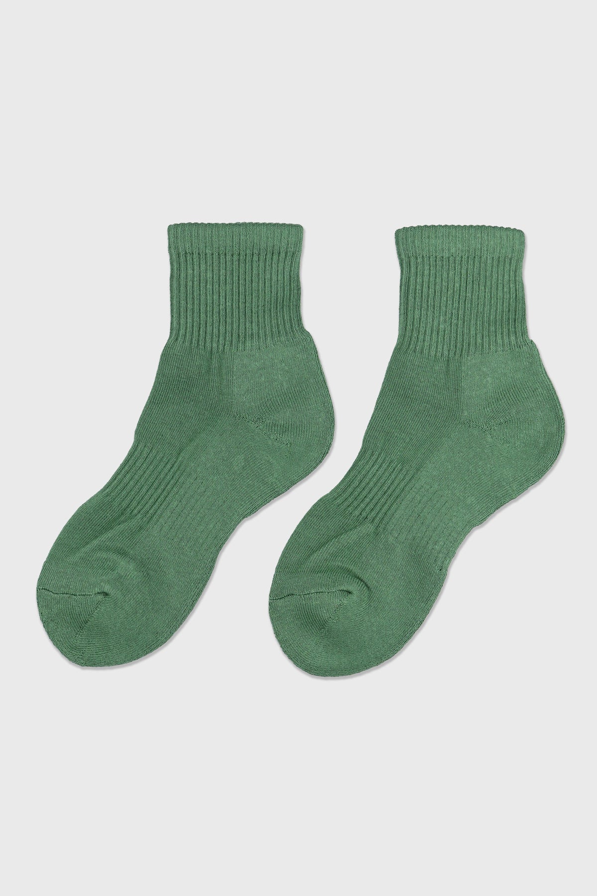 A pair of medium green ribbed ankle socks displayed flat against a light gray background.