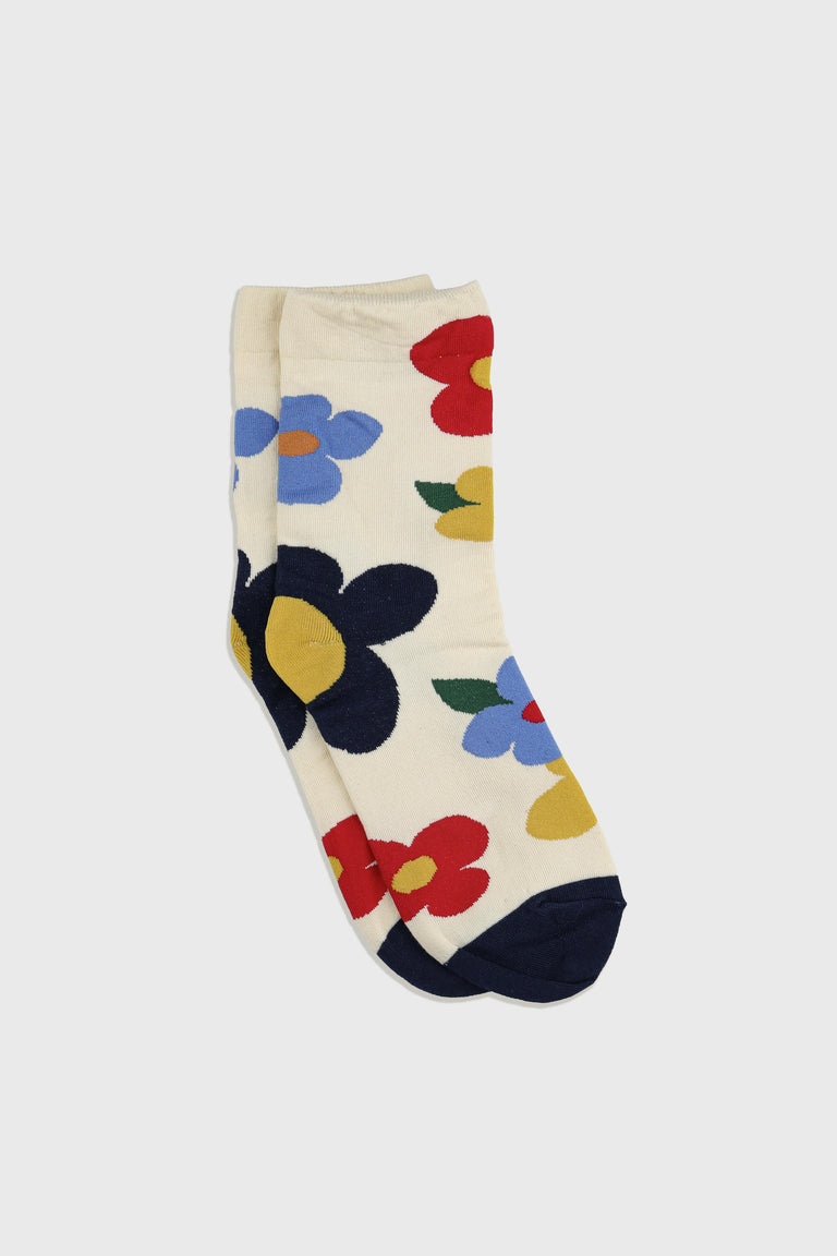 A pair of cream-colored crew socks featuring a bold, colorful floral pattern with navy, red, blue, yellow, and green flowers, displayed on a light gray background.