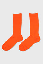 A pair of bright neon orange crew socks displayed flat against a light gray background.