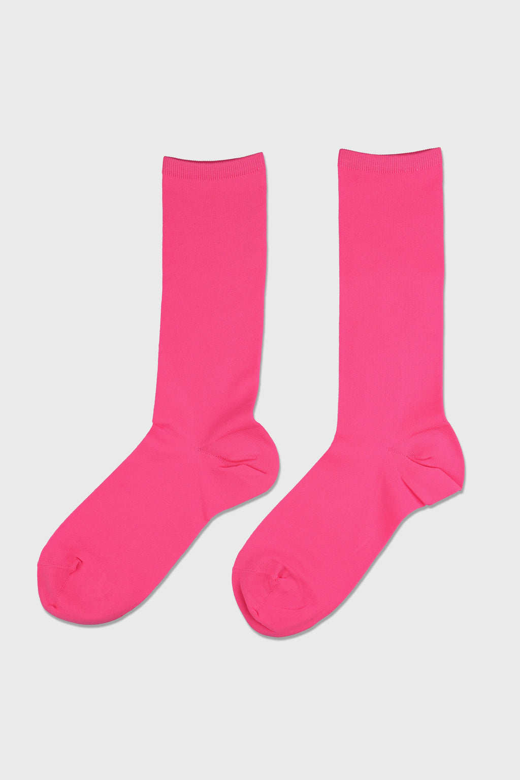 A pair of bright pink crew socks displayed flat against a light gray background.
