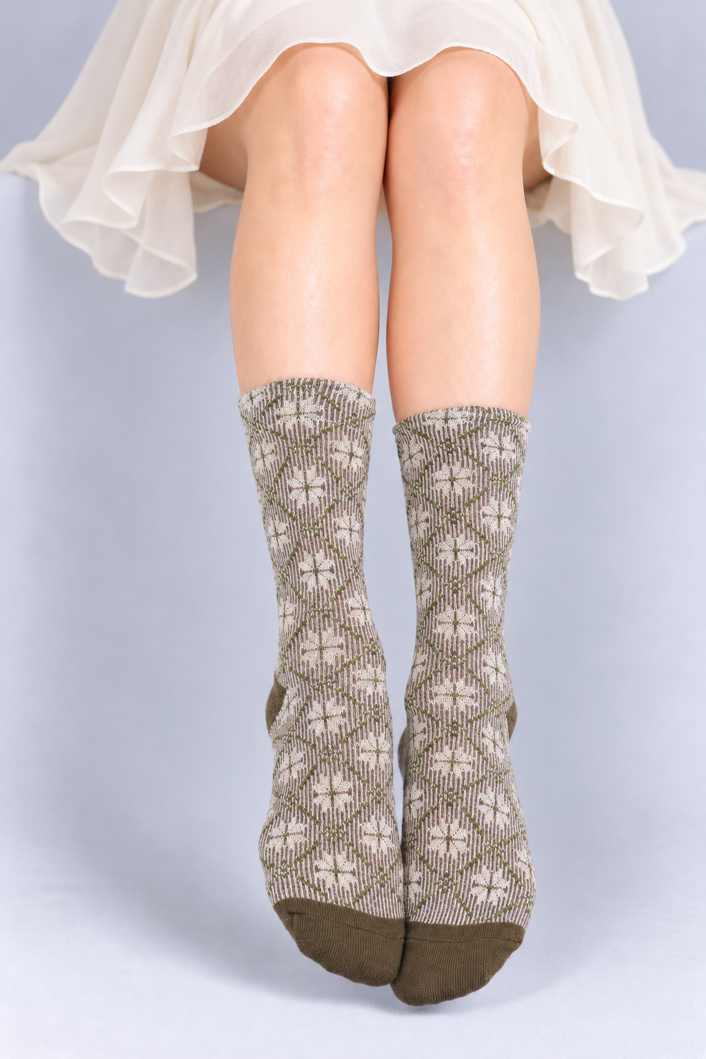 Women's Premium Combed Cotton Metallic Sparkle Crew Socks-A person's legs wearing knee-high patterned socks with a cream and taupe geometric design and solid taupe heels and toes, shown against a light gray studio background.