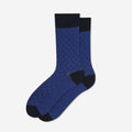 A pair of blue crew socks with a textured geometric pattern, solid black cuffs, heels, and toes, displayed against a clean white background.