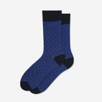 A pair of blue crew socks with a textured geometric pattern, solid black cuffs, heels, and toes, displayed against a clean white background.