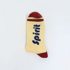 A single ribbed ankle sock in pale yellow with a dark red toe and heel, and the word 'Spirit' printed vertically in dark blue. The sock is photographed flat against a plain white background.