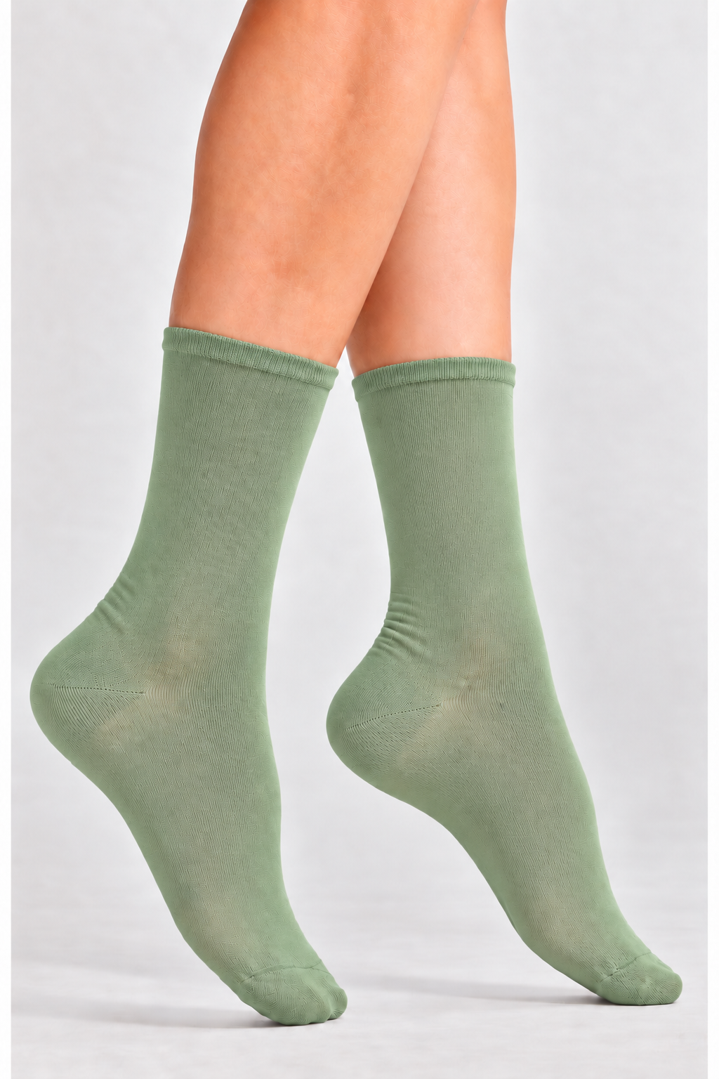 Women's Ultra-Lightweight Breathable Crew Socks-Cooling Performance Olive-A pair of light sage green crew socks worn on a person's feet, shown against a plain light gray studio background.